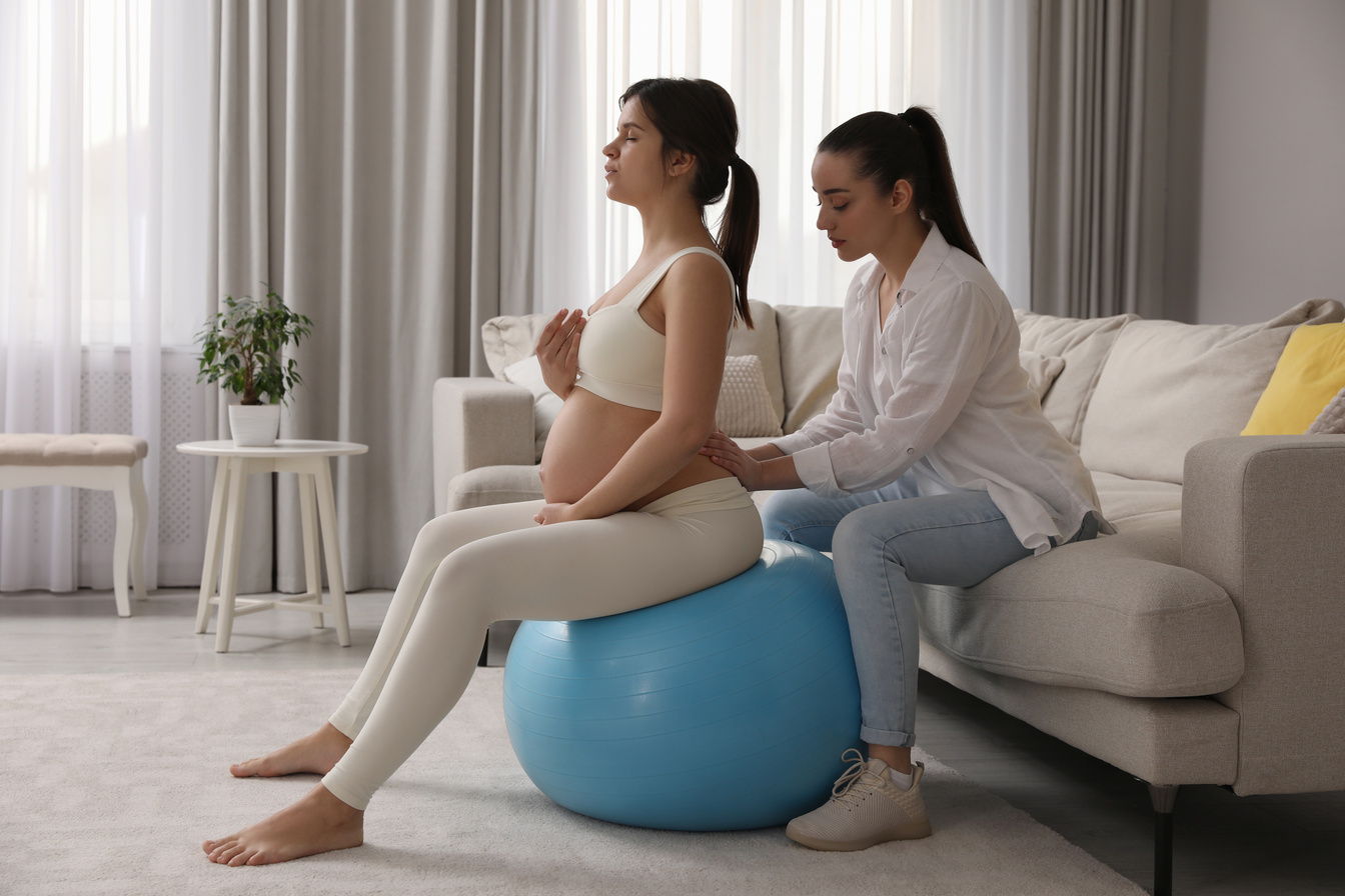Doula Massaging the Back of Pregnant Woman in Living Room